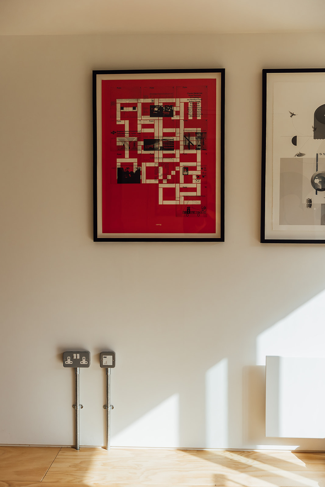 A white wall with a photoframe showing some art of a building layout